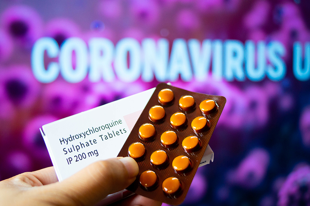 Hydroxychloroquine Sulphate tablets with coronavirus written in background