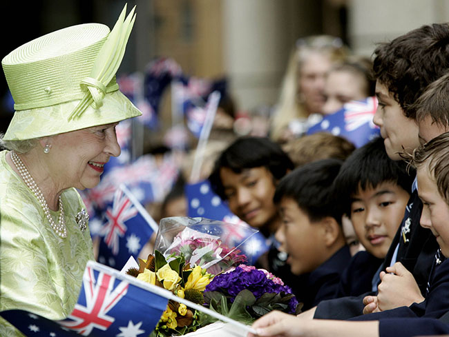 Britain's Queen Elizabeth ll left, receives flowers from waiting school children after the Commonwealth Day Service in Sydney, Monday, March 13, 2006. The Queen will open the Melbourne Commonwealth Games on March 15, 2006. (AAP Image/AP POOL/Rob Griffith) NO ARCHIVING