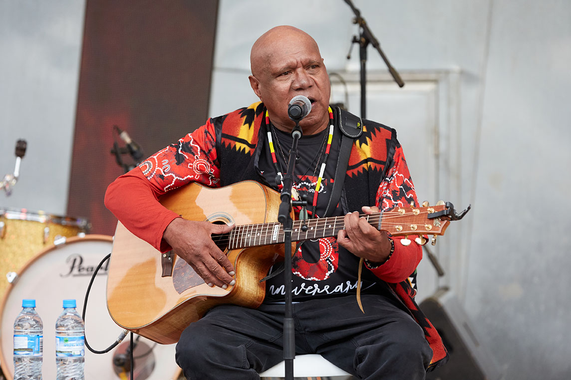 Archibald 'Archie' Roach performs during the annual Long Walk celebrations before the Dreamtime at the 'G clash between Essendon and Richmond in Melbourne, Saturday, May 25, 2019. The Long Walk aims to get the lives of Indigenous people back on the national agenda. (AAP Image/Erik Anderson) NO ARCHIVING