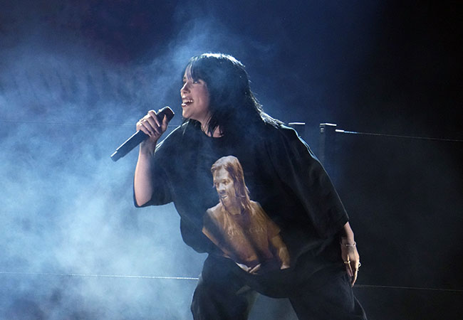 Apr 3, 2022; Las Vegas, NV, USA;   Finneas (l) and Billie Eilish perform Happier Than Ever during the 64th Annual Grammy Awards at the MGM Grand Garden Arena in Las Vegas. EIlish is wearing a shirt featuring an image of Foo Fighters drummer Taylor Hawkins. Mandatory Credit: Robert Hanashiro-USA TODAY/Sipa USA /AAP Image
