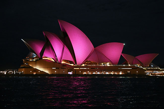 The sails of the Sydney Opera House are lit up with the colour pink as a tribute to Olivia Newton-John, Sydney, Wednesday, August 10, 2022. Olivia Newton-John, the singing superstar who won viewers' hearts as Sandy in the blockbuster musical Grease, has died aged 73 at her home in California. (AAP Image/Steven Saphore) NO ARCHIVING