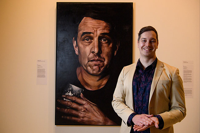 Artist Jeremy Eden poses with his painting of actor Samuel Johnson, after winning the ANZ Archibald People’s Choice Award 2022 at the Art Gallery of New South Wales in Sydney, Wednesday, August 3, 2022. (AAP Image/Bianca De Marchi) NO ARCHIVING